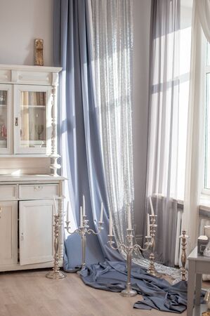 Blue curtains and candlesticks on the floorの写真素材