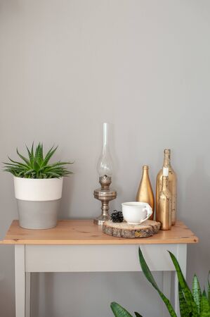 Table with flower, kerosene lamp, bottles and a cupの写真素材