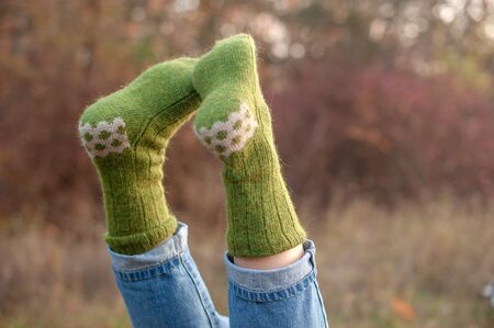 Handmade knitted socks on the background of nature