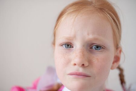Close-up of a sad red-haired schoolgirl