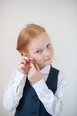 Red-haired girl ties braidsの写真素材