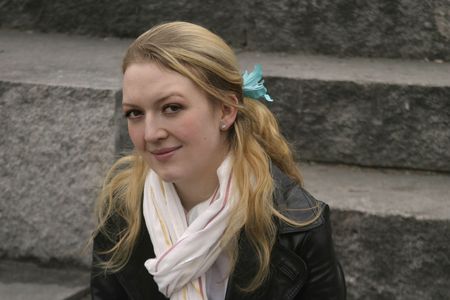 Portrait of a young woman sitting on stone stepsの写真素材