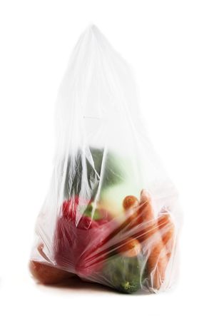 Healthy vegetables in a clear plastic grocery bag on a white backgroundの写真素材