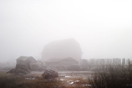 Winter farmyard in fogの写真素材