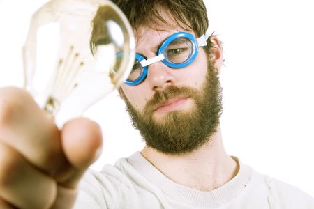 A concept image protraying a funny / good idea.  A young funny looking bearded male with swimming goggles holding up a light bulb.の写真素材