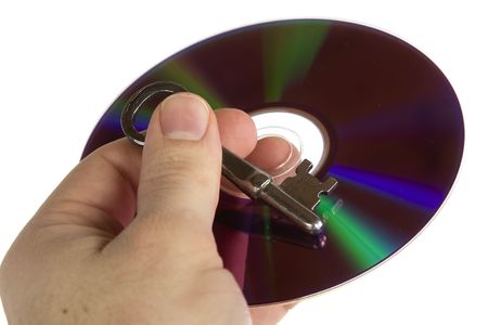 A skeleton key and a computer disk being held by a males hand, isolated on white の写真素材