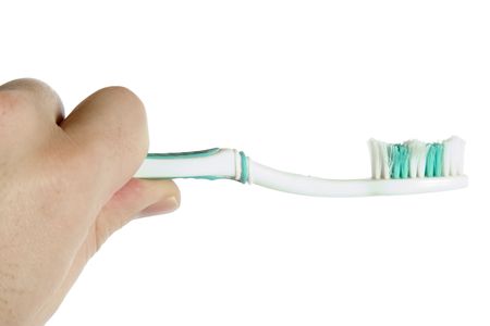 A worn out toothbrush in the hand of a male.の写真素材
