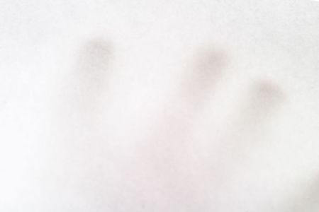 A males hand holding up a white paper with nothing on it, texture background image.  The hand is bairly visible behind the opaque paper.の写真素材
