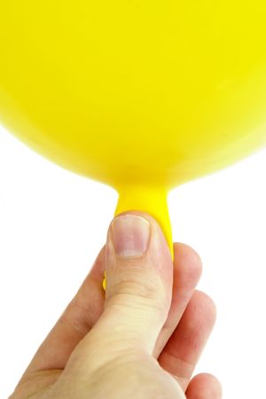 A yellow baloon being held in a hand.  Isolated on whiteの写真素材