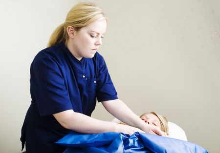 A detail image of a woman being wrapped during a sea mud full body wrap at a luxury spa.の写真素材
