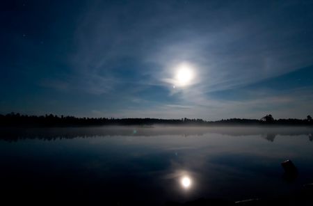 A landscape of a lake at night with the moonの写真素材