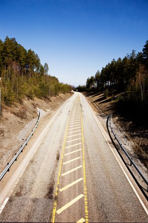 A highway stretching into the distance with a blue sky.の写真素材