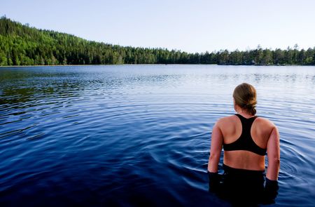 A female swimming in a lake in the evening sunの写真素材