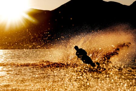 A male waterskiing in the evening sunsetの写真素材