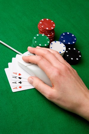 An online gambling concept - computer mouse, hand and casino chips