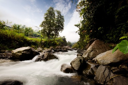 A rapid flowing river with motion blur on the waterの写真素材