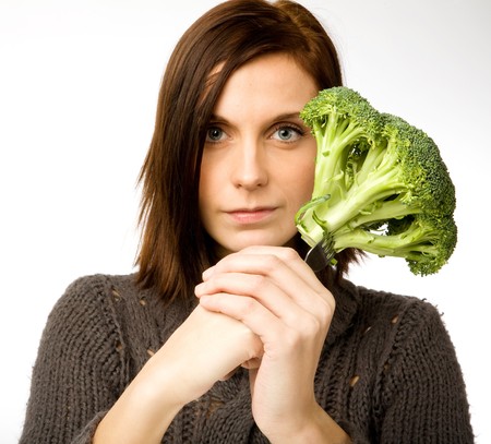 A woman with broccoli in handの写真素材