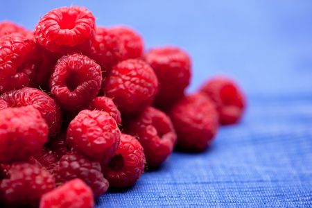 Fresh raspberries isolated on a blue cloth