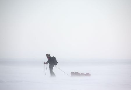 A single person on a winter expedition in a snow stormの写真素材