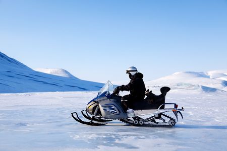 A snowmobile on a beautiful winter mountain landscapeの写真素材