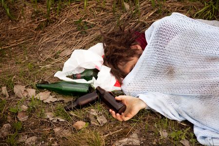 A drunk homeless man sleeping in a ditchの写真素材