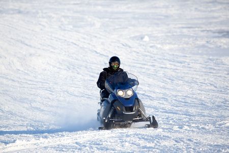 A snowmobile isolated against a winter snow landscapeの写真素材
