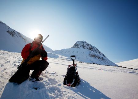 A female adventure loading a rifle as a safety precatuion, Svalbard, Norwayの写真素材
