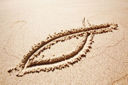 A fish symbol in drawn in the sandの写真素材