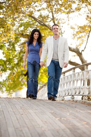 A couple walking on a bridge in a parkの写真素材