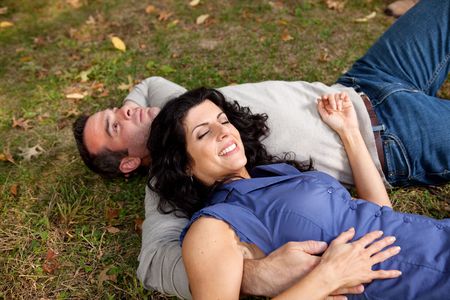 A couple laying on grass in a parkの写真素材