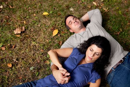 A couple laying on grass dreaming - sharp focus on femaleの写真素材