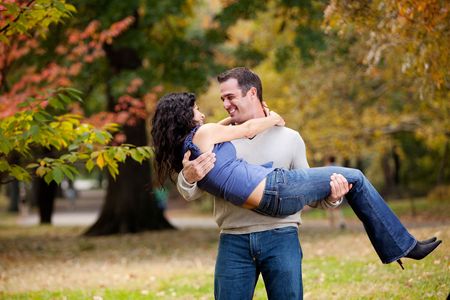 A man holding a woman in a park - happy coupleの写真素材