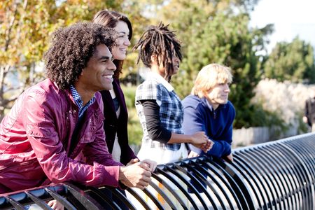 A group of friends outside in a park having fun - shallow depth of field with sharp focus on first...