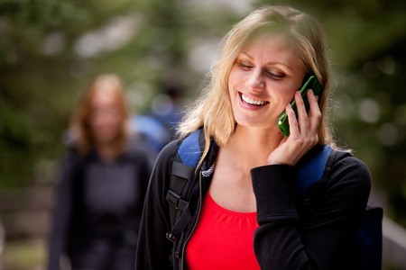 A happy woman talking on a cell phone outdoorsの写真素材