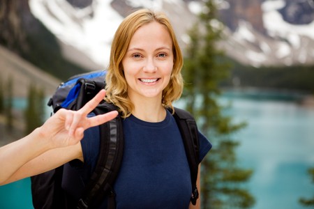 A portrait of a happy smiling girl with a mountain lake in the distant backgroundの写真素材