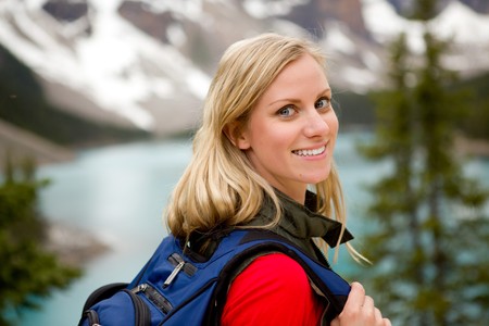 A portrait of a pretty woman in front of a mountain landscape, Lake Moraine, Alberta, Canadaの写真素材