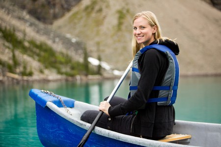 A portrait of a happy woman canoeing on a glacial lakeの写真素材