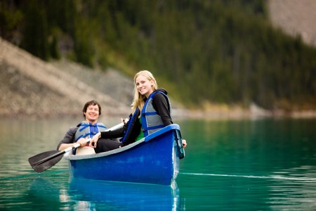 A portrait of a happy woman on a canoeing trip with a manの写真素材