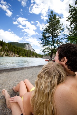 A couple relaxing near a river in Banff, Canadaの写真素材