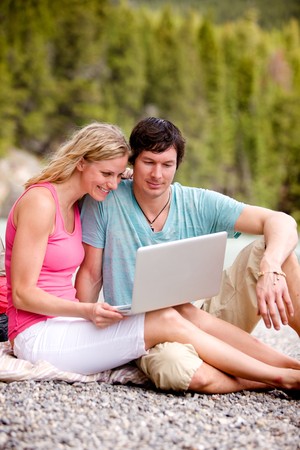 A couple enjoying a laptop computer outdoorsの写真素材