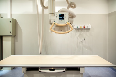 An empty x-ray room with an x-ray machine and tableの写真素材