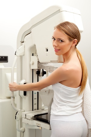 A young woman having taking a mammogram, looking at the cameraの写真素材