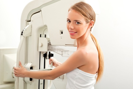 A young woman having taking a mammogram, looking at the cameraの写真素材