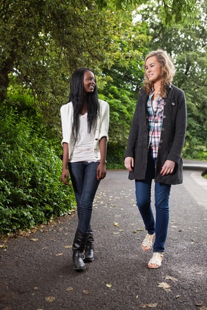 Two young women enjoying walk in the parkの写真素材