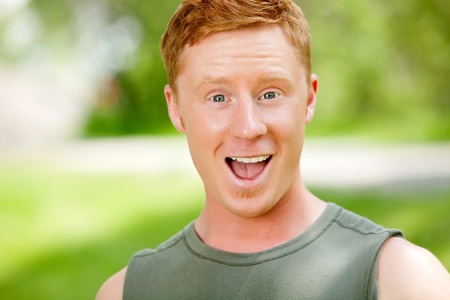 Excited man with mouth open against blur backgroundの写真素材