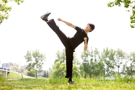 Young Martial artist with his high side kick against blur backgroundの写真素材