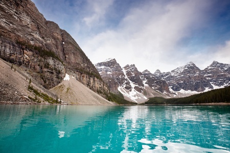 Scenic shot of calm blue water and mountain range against skyの写真素材