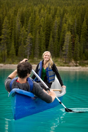 A happy couple canoeing on a glacial lakeの写真素材
