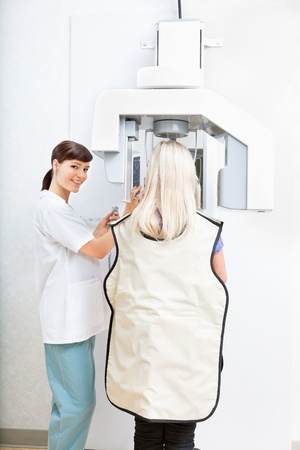 Young female orthodontist taking a panoramic digital xray of a patient`s teethの写真素材
