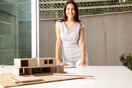A young architect in an office with a rough model of a houseの写真素材